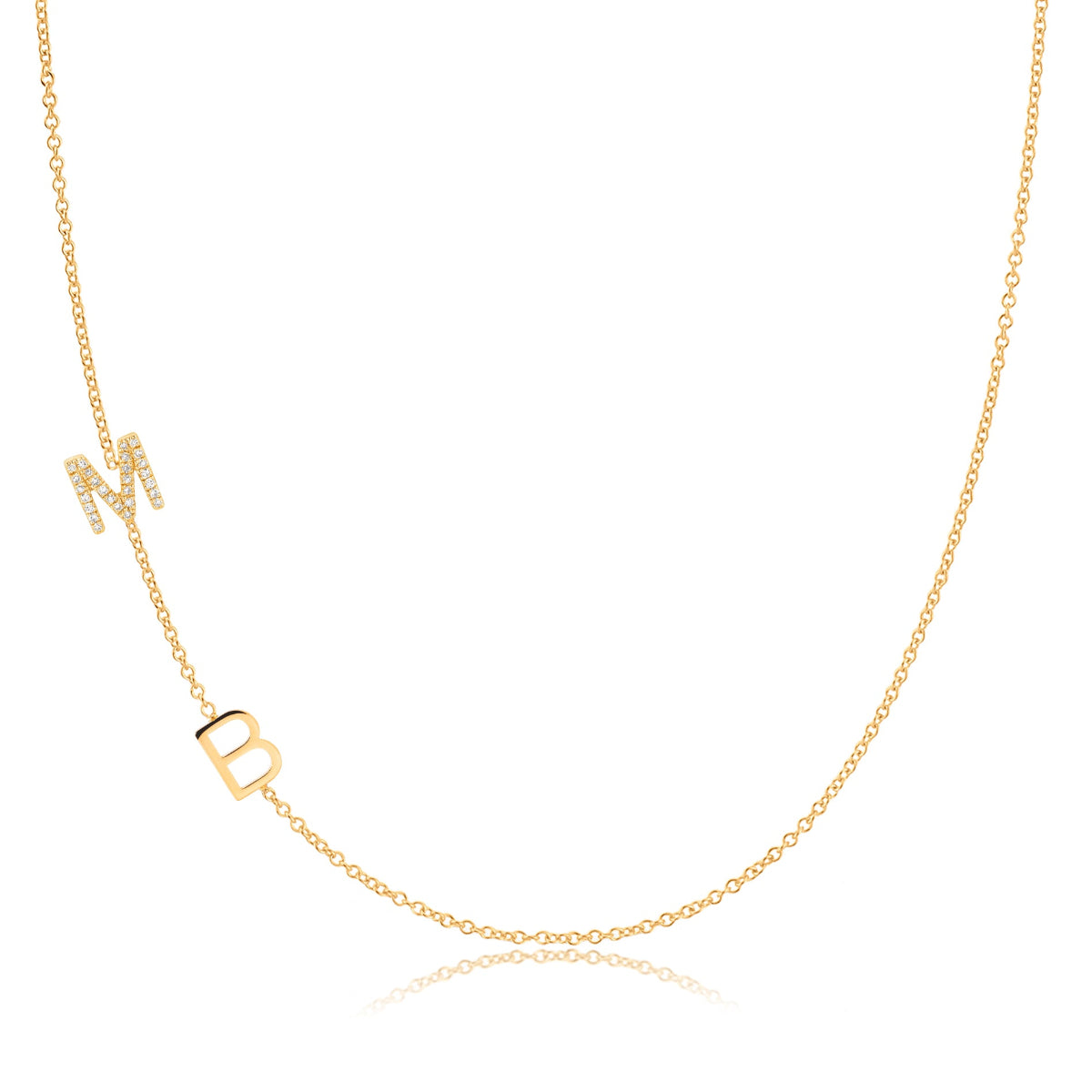 A Custom Gold Necklace in yellow gold with two letter charms, a pavé M and a B positioned on the left side of the necklace, on a white background.