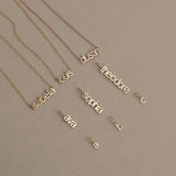 Gold name necklaces on a beige background