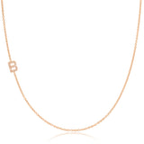 A rose gold necklace with a pave letter B charm on a white background.