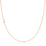 A rose gold necklace with a pave letter J charm on a white background.