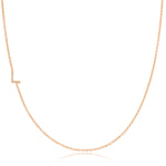 A rose gold necklace with a pave letter L charm on a white background.