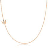A rose gold necklace with a W letter charm on a white background.