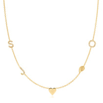 A Custom Gold Necklace in yellow gold with five charms, pave letters S, J and O, a heart and an angel wing, on a white background. 