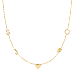 A Custom Gold Necklace in yellow gold with five charms, pave letters S, J and O, a heart and an angel wing, on a white background. 
