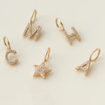 Pave Letter Charms in C, M, H and A and a Charm Pendant in Pave Star against a cream background. 