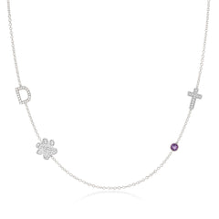 A Custom Gold Necklace in white gold with four charms, a pavé D and a paw positioned on the left side of the necklace, and a pavé cross and birthstone positioned on the right, on a white background.