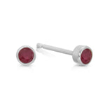 A pair of Birthstone Studs - Ruby (July) in white gold on a white background.