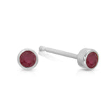 A pair of Birthstone Studs - Ruby (July) in white gold on a white background.
