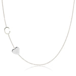 A Monogram Necklace with Heart White Gold and a letter C charm on a white background.