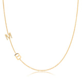 A Custom Gold Necklace in yellow gold with two letter charms, a pavé M and a B positioned on the left side of the necklace, on a white background.