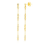 A pair of Stardust Earrings in yellow gold on a white background. 