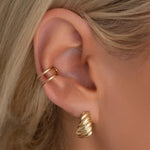 Close-up of an Etched Paris Earring and Double Ear Cuff on a blonde woman's ear. 
