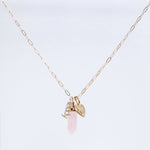 An Element Short Link Chain with a Petite Nameplate Pendant reading “teddy,” an Engraved Heart Charm, and a Balance Crystal Charm, shown against a light grey background.