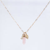 An Element Short Link Chain with a Petite Nameplate Pendant reading “teddy,” an Engraved Heart Charm, and a Balance Crystal Charm, shown against a light grey background.