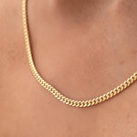 Close-up of a neck wearing a Chic Cuban Curb Chain in yellow gold. 