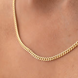 Close-up of a neck wearing a Chic Cuban Curb Chain in yellow gold. 