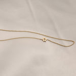 A yellow gold cable chain 14k Gold Asymmetrical Charm Necklace - Star of David against a light grey fabric background.