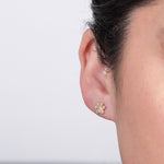 Close-up of a Pavé Charm Stud - Paw in a woman's ear against a light grey background. 