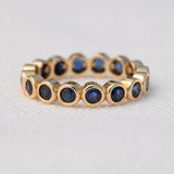 The Iris Bouquet Ring in yellow gold against a light grey background. 