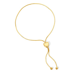 The Slide Heart Bracelet in yellow gold on a white background. 