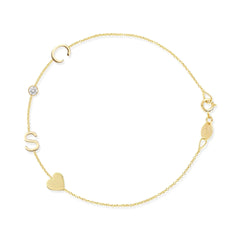 Gold bracelet with letter 'S', heart, and round charm on a white background