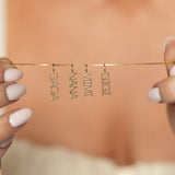 Gold necklace with grandma names held by hands against a blurred background