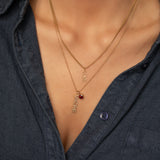 Necklaces with 'LOVE' and 'MADRE' pendants layered on a person wearing a dark shirt.