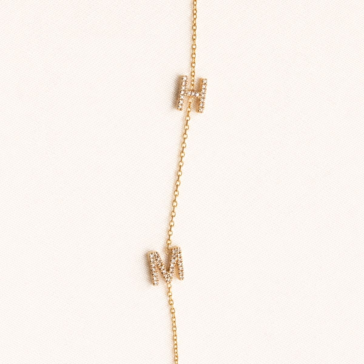 Gold necklace with small rectangular pendants on a white background