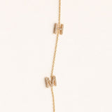 Gold necklace with small rectangular pendants on a white background