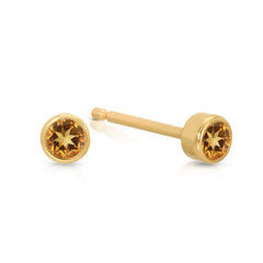 A pair of solid 14k gold birthstone stud earrings featuring 2.5 mm natural citrine stones set in a 3mm bezel.