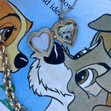 Gold heart-shaped locket with a small photo of a white dog.