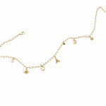 Gold necklace with various charms on a white background