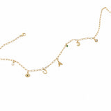 Gold necklace with various charms on a white background