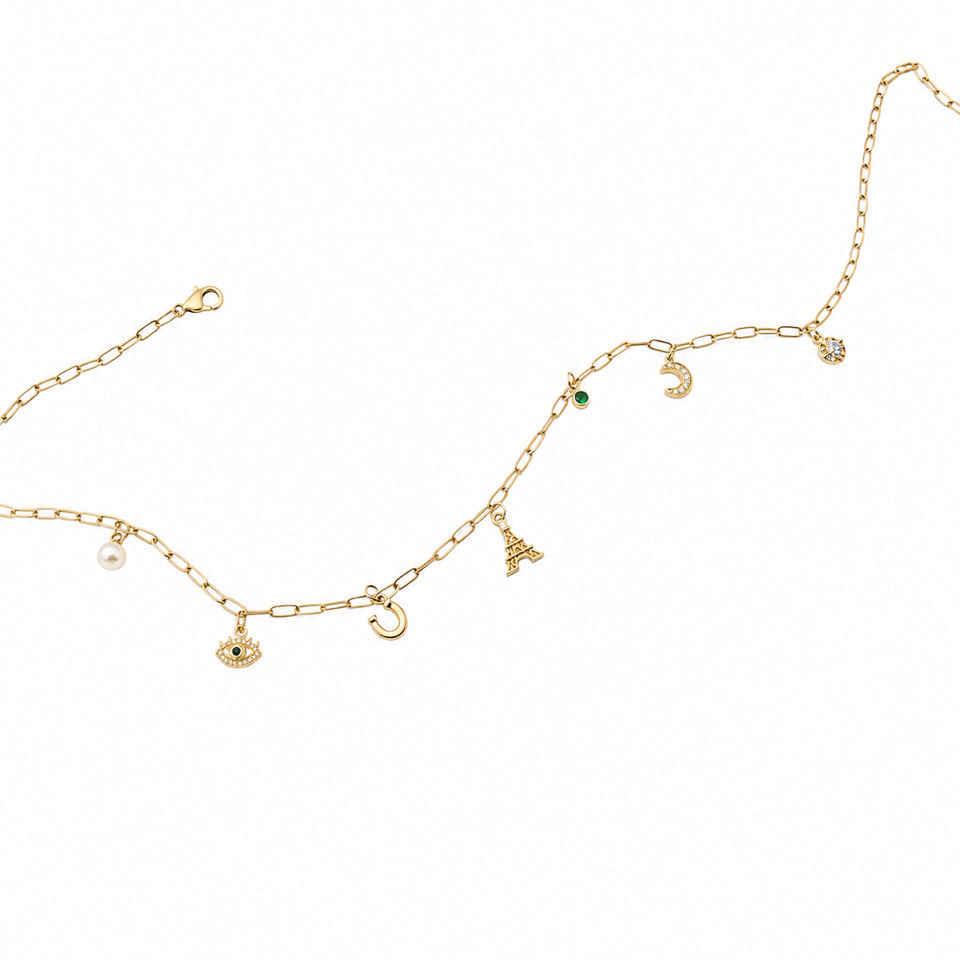 Gold necklace with various charms on a white background