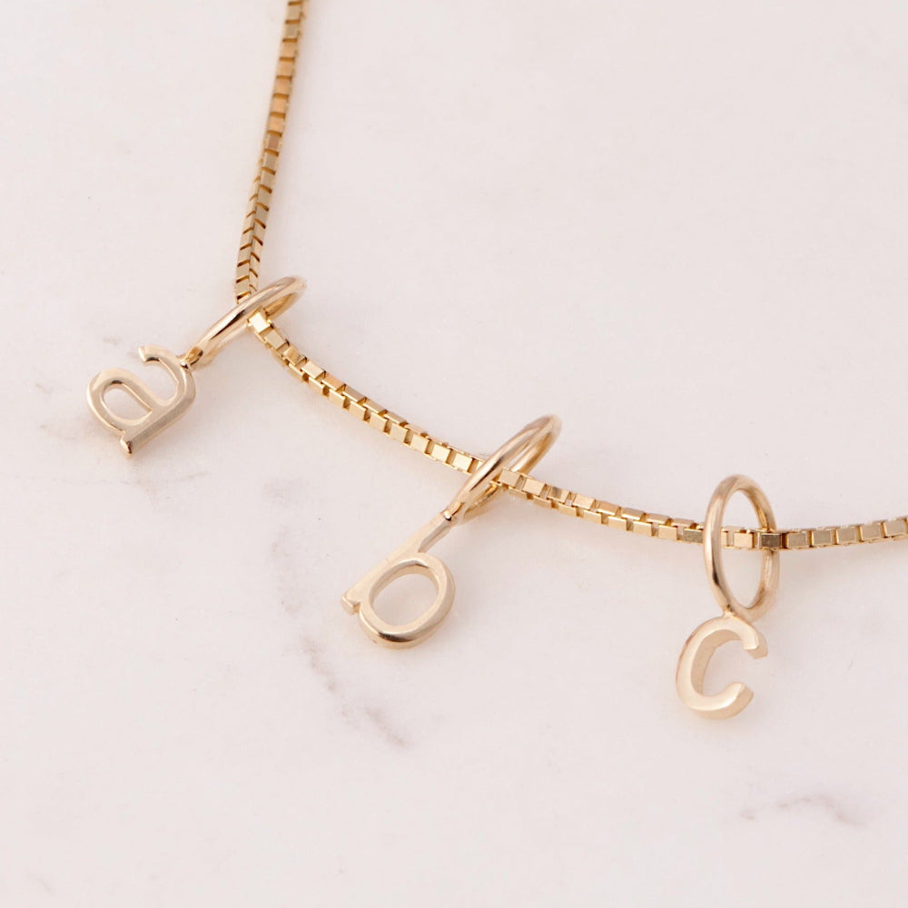 Gold necklace with letter pendants A B C 