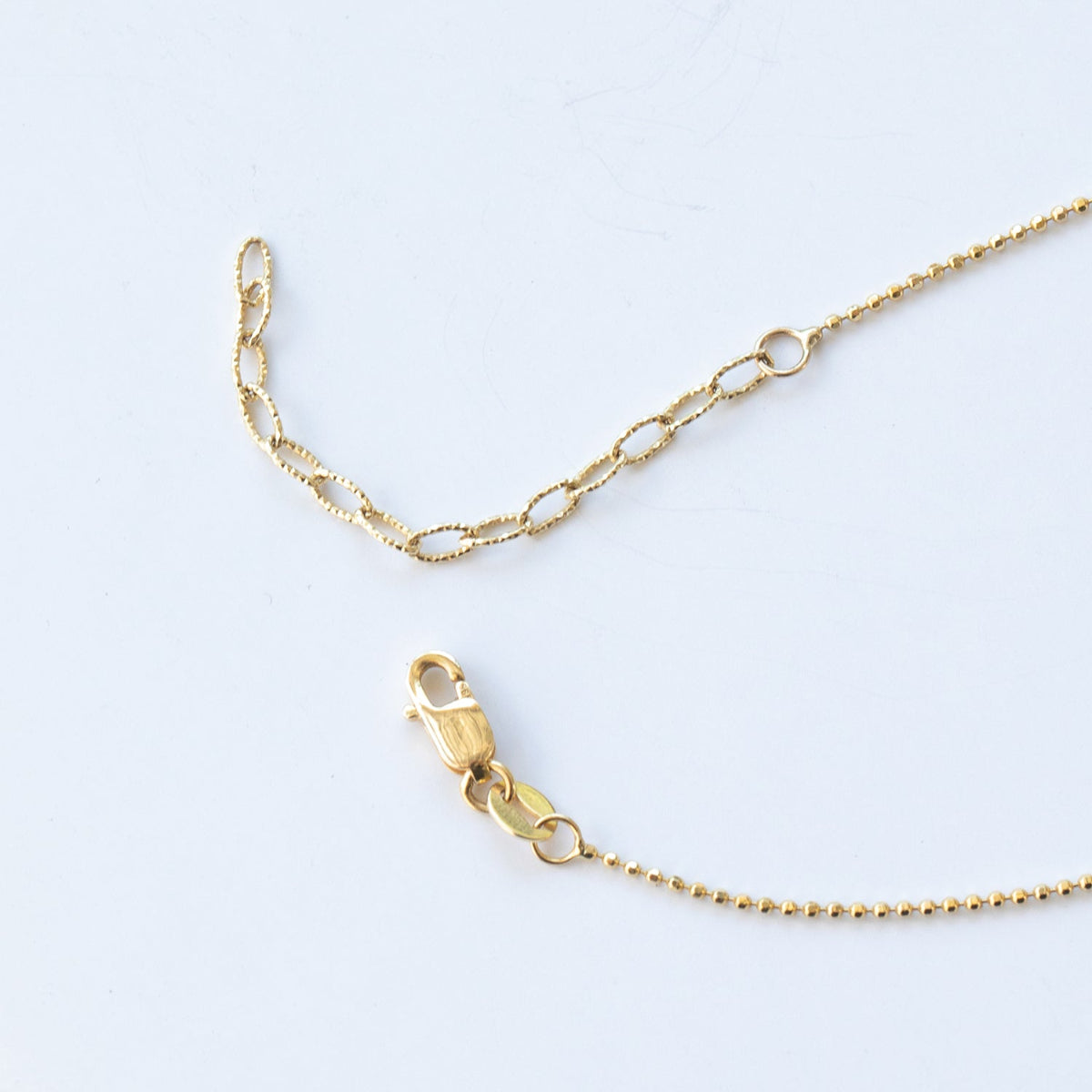 The back of a Stardust Diamond Necklace, showing the lobster clap on a white background. 