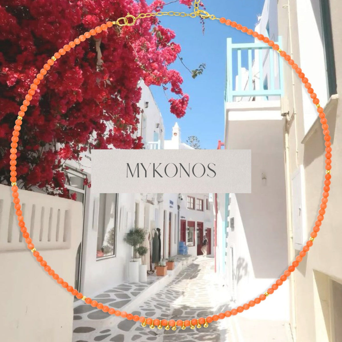 An Endless Summer Necklace – Mykonos with Mykonos streets featuring white buildings and red flowers as the background, with the word ‘MYKONOS’ in the centre.