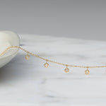 A Stardust Diamond Necklace against a white and grey marble background. 