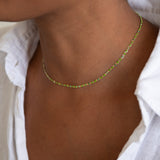 A close-up of a neck wearing a Confetti Necklace - Green. 