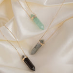 Three Retreat Necklaces - Protection, Courage and In Flow on a cream silk background. 