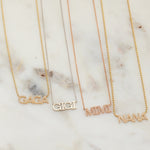 A Pavé GAGA Necklace in yellow gold, a GIGI Necklace in white gold, a Pavé MIMI Necklace in rose gold, and a Pavé NANA Necklace in yellow gold, displayed on a light marble surface.