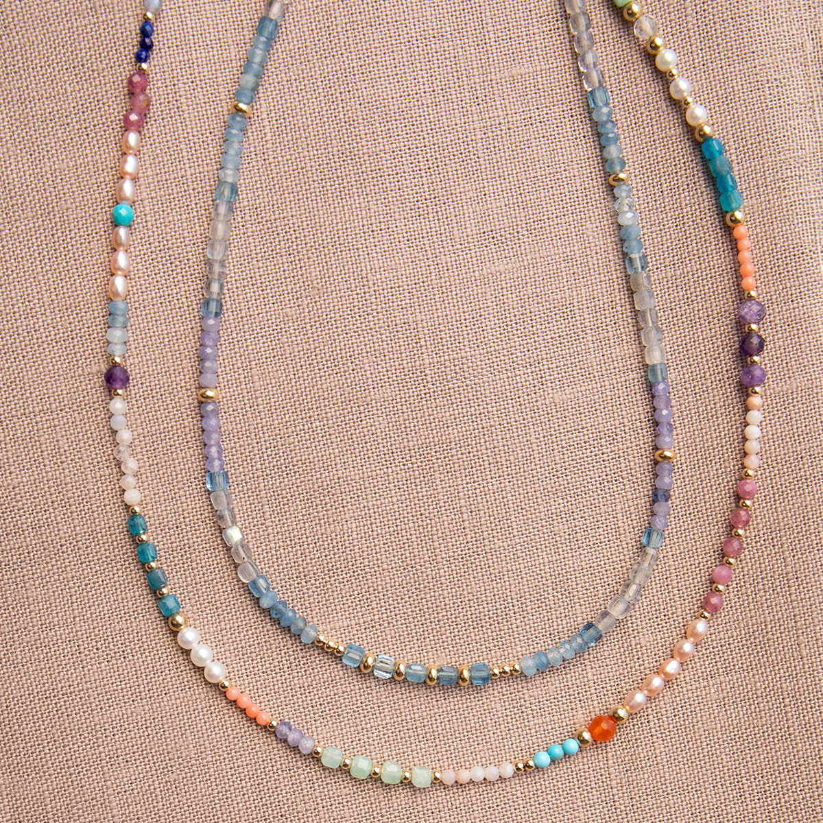 Endless Summer Necklaces - Capri and Blue Lagoon against a neutral fabric background. 