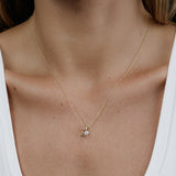 A woman's decellotage wearing a yellow gold Signature Cable Chain with a Gold Letter Jumble - A. 