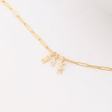 An Element Long Link Chain with three Petite Nameplate Pendants, 'lara', 'd' and 'livia', all in yellow gold on a white background. 