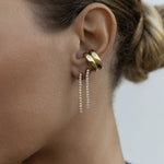 Close-up of an ear wearing two Down the Line Earrings and two yellow gold Ready to Mingle Ear Cuffs. 