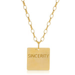 The back of a Virtues Pendant - Square in yellow gold with 'SINCERITY' engraved on a white background. 