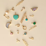 Collection of gold and colorful pendants on a beige background