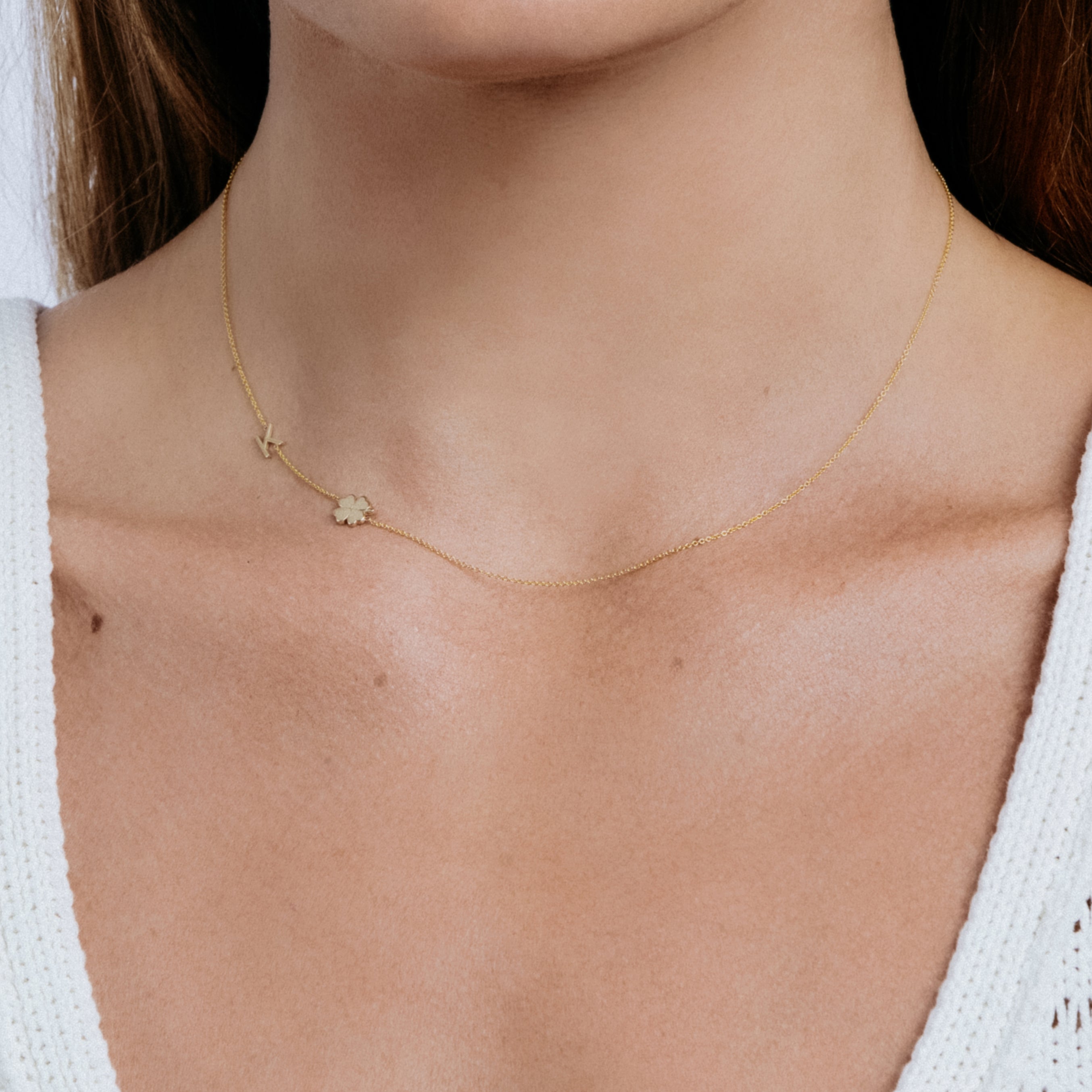 Gold necklace with a small pendant on a person's neck