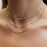 Close-up of a neck wearing three layered Confetti Necklaces - Yellow. 
