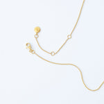 The back of a yellow gold Diamond Drip Necklace, showing a lobster clasp on a white background. 